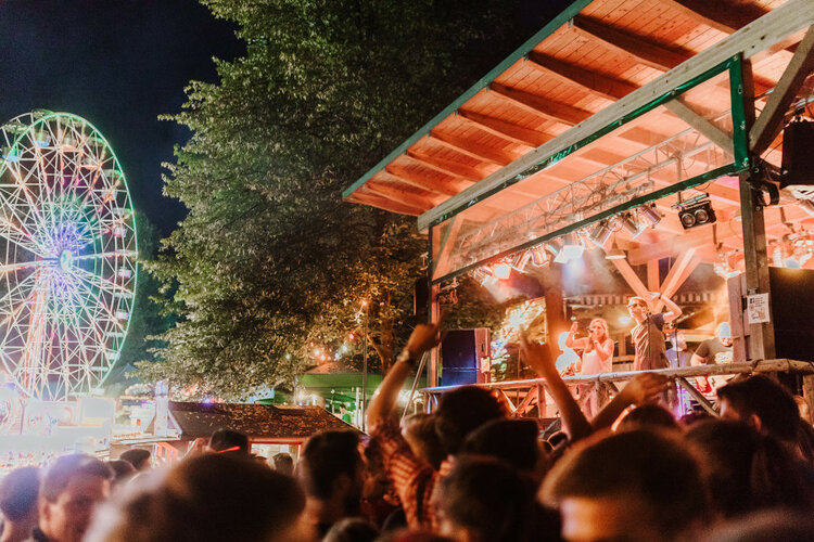 Annafest bei Nacht mit Bühne und Musikern und vielen Leuten davor, Hintergrund beleuchtetes Riesenrad